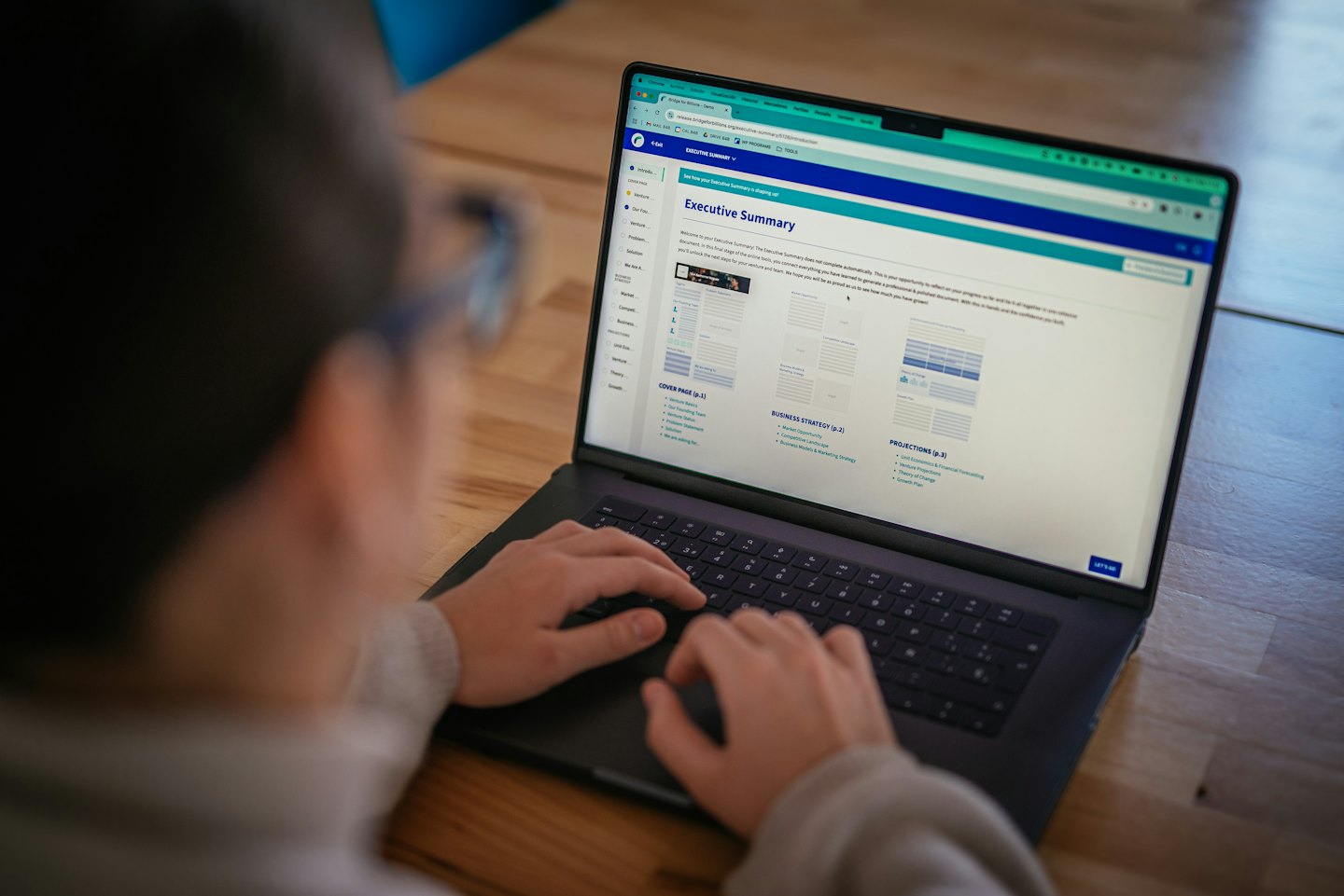 Profesjonalista piszący streszczenie wykonawcze na laptopie.